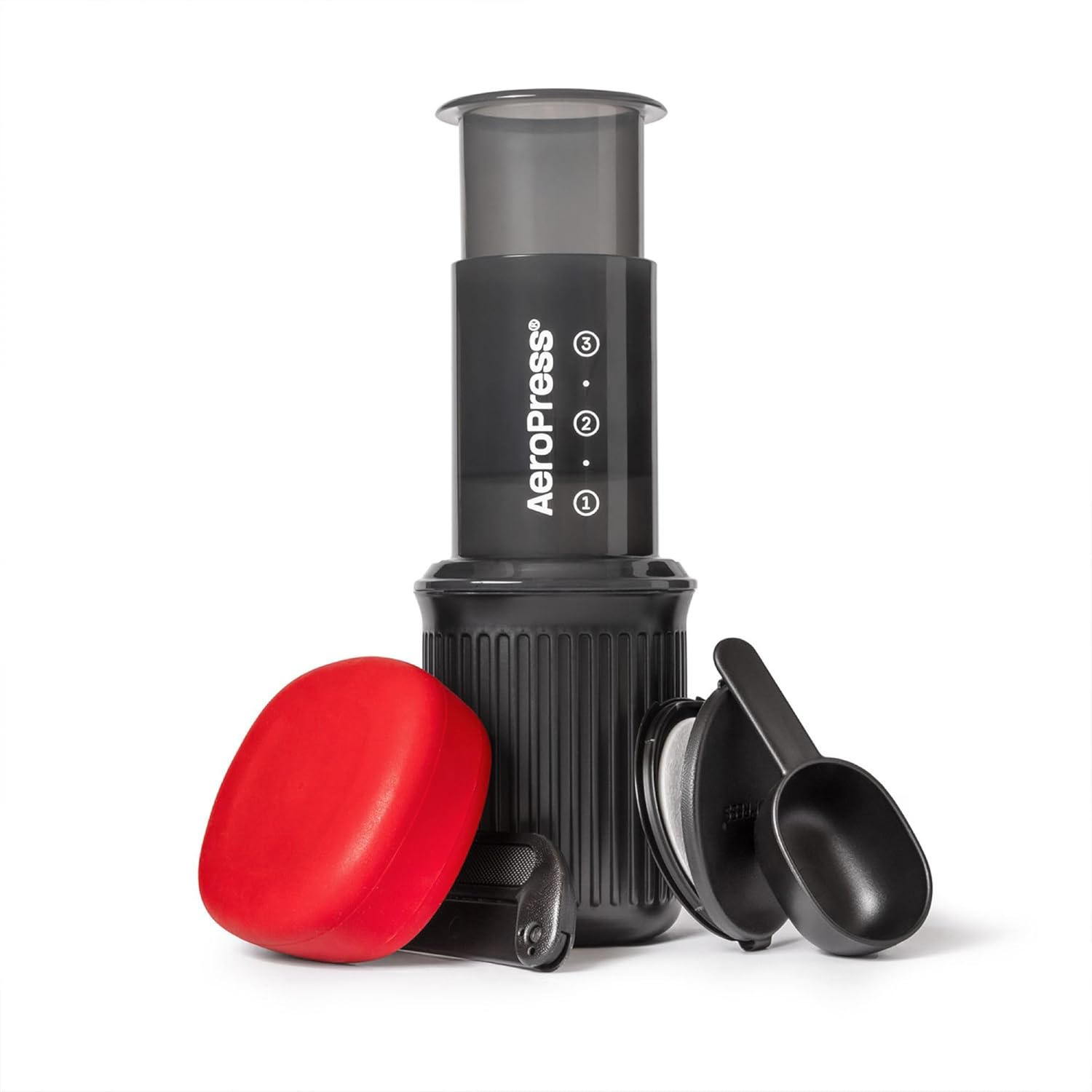 Aeropress coffee maker with red lid and black scoop on a white background