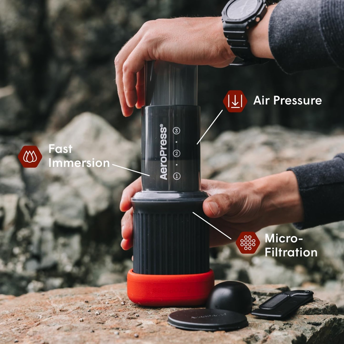 Aeropress coffee maker being used outdoors with labeled features.