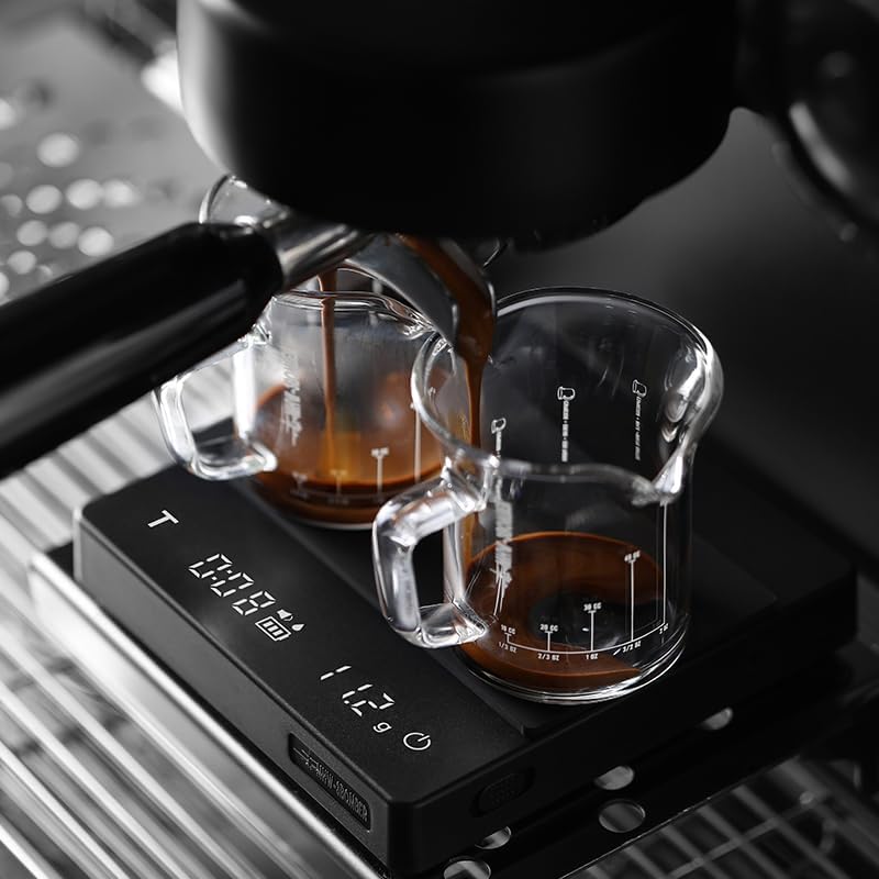 Espresso machine with two glass cups on a digital scale, capturing the process of making coffee.