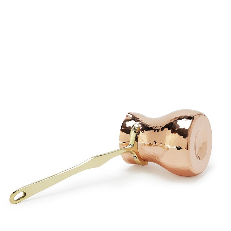 Copper muddler with gold handle on a white background
